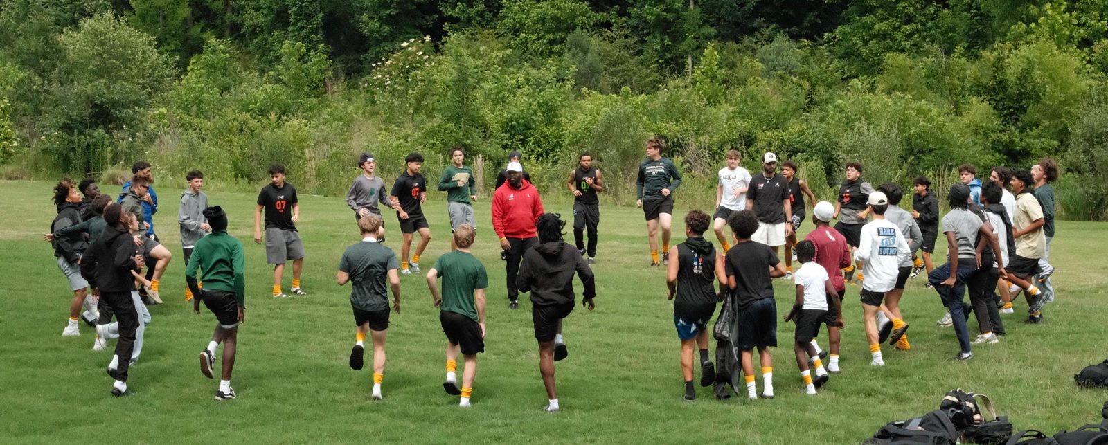 TOUR athletes warming up together in a circle with a coach